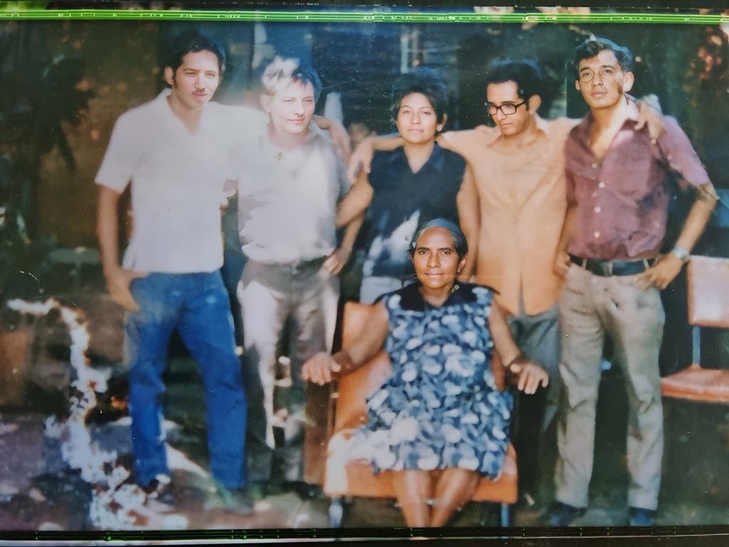 Foto familiar antigua escaneada, cinco hijos adultos de pie detrás de su madre sentada, Rosa. Efraín está de pie al fondo con sus hermanos, el segundo por la derecha, con gafas negras de montura gruesa.