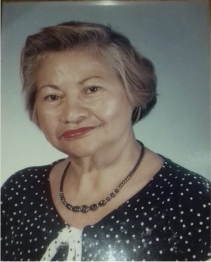 Foto de Iris sonriendo a la cámara, con el pelo corto y un vestido negro con puntos blancos.