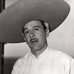 Foto en blanco y negro del cantante Pedro Infante con bigote, con expresión melancólica, con un sombrero grande y una camisa blanca de cuello corto.